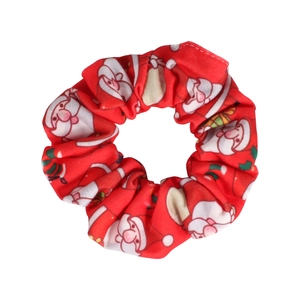 Close-up of red Christmas scrunchie with festive Santa Claus patterns and elastic fabric