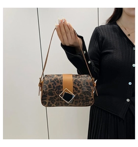 Detailed close-up of leopard print shoulder bag with geometric metal buckle and fine texture