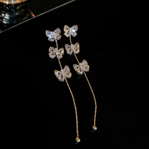 Gros plan de boucles d'oreilles nœud en argent avec zircons sur fond miroir noir chic