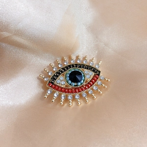 Retro evil eye brooch in gold finish with colorful rhinestones and enamel details