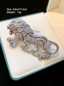 Macro shot of silver lion brooch with clear gems on velvet, size 6.0cm by 3.2cm