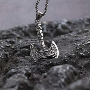 Macro view of Viking eagle and double axe pendant on a rugged dark stone surface