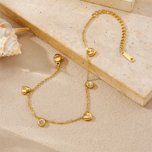 Elegant gold heart charm bracelet with zircons and stainless steel chain on stone decor