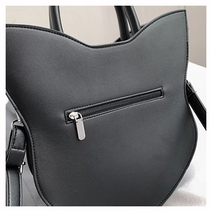 Close-up of black cat ear handbag back showing litchi texture and zipper pocket