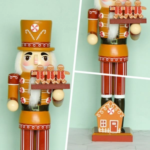 Gingerbread nutcracker chef figure in yellow and red with candy house details