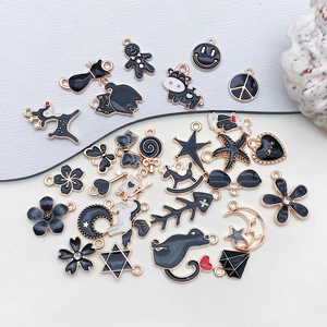 Collection of black enamel gold charms in animal, star, and heart shapes for DIY jewelry