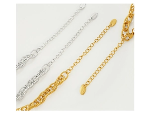 Macro view of gold and silver stainless steel extender chains with S.Steel logo tags