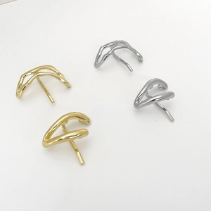 Macro view of abstract gold and silver U-shaped metal hairpins in minimalist flow design
