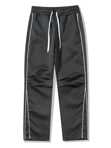 Detail of black sports trousers with white side stripes and adjustable drawstring waist