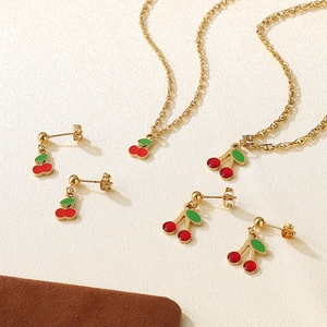 Dettaglio parure gioielli ciliegia con collana e orecchini in smalto rosso e oro