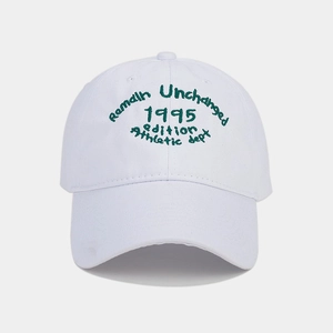 Detailed close-up of dark green embroidery on a white cotton baseball cap