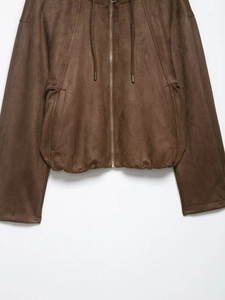 Detail of dark brown faux suede texture with metallic zipper and hood drawstring