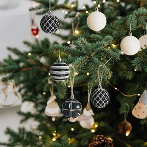 Black and white painted Christmas tree ornaments with glitter grid and stripe designs