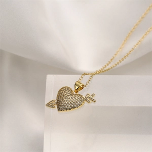 Collier doré avec pendentif cœur et flèche serti de zircons sur support géométrique