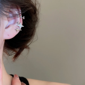 Detail of silver ear cuff set with star zircons and rectangular gems on model's ear
