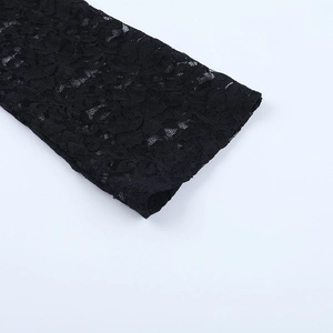 Gros plan des motifs floraux complexes sur la manche en dentelle noire de la robe