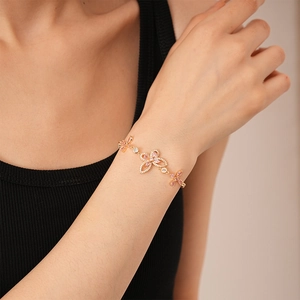Elegant gold butterfly and flower bracelet with pink zircons on a woman's wrist