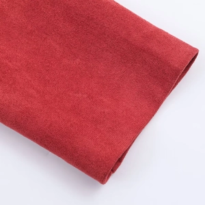Detailed close-up showing the fine fiber texture of red faux suede jacket fabric