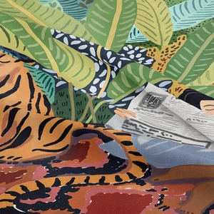 Macro view of woven tapestry fabric showing leopard print and jungle plant details