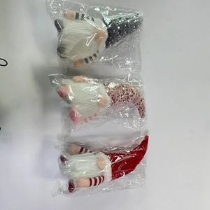 Three Christmas gnomes with sequined hats in individual plastic packaging bags