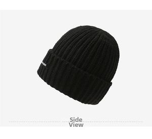 Detail view of black ribbed knit beanie showing fine texture and side textile label