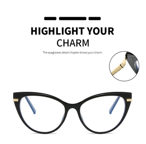 Close-up of the metal hinge and gold decorative accents on black cat-eye eyeglass frames