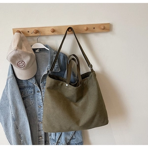 Close-up of military green canvas tote bag showing thick material and dual straps detail