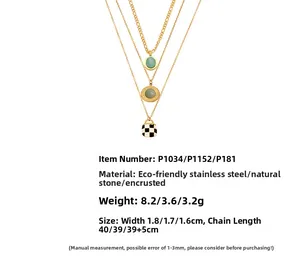 Detail view of turquoise pendants and checkerboard charms on gold stainless steel chains
