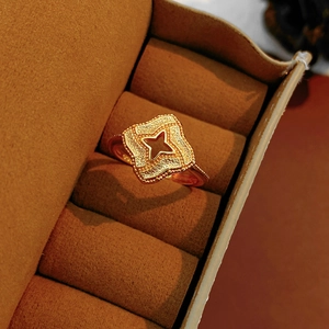Vue rapprochée d'une bague trèfle vintage plaquée or sur un écrin en velours foncé