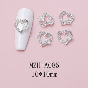 Macro shot of silver heart-shaped nail charm with rhinestones and 3D butterfly design
