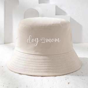 Detail view of beige cotton bucket hat featuring dog mom print and paw icon