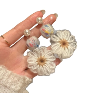 Handmade crochet flower earrings with white pearls and colorful yarn ball details