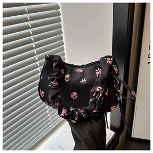 Detail of black mini handbag with pink rose pattern and pleated scrunchie handle