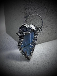 Detail of gothic silver skull claw pendant with luminous blue labradorite gemstone