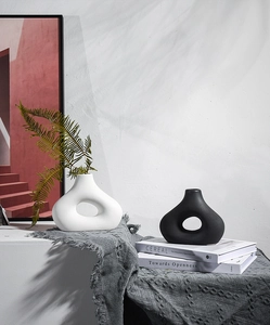 Detail van minimalistische zwarte en witte keramische vazen met organische holle vormen