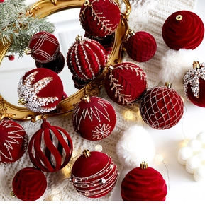 Detailed view of red flocked and pearl-studded Christmas balls on a festive knit background