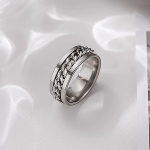 Macro shot of silver spinner ring with rotating cuban link chain inlay and polished finish
