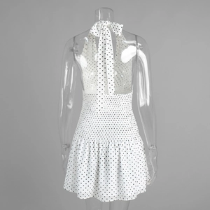 Detailed back view of a polka dot halter dress featuring a tied bow and smocked waistline