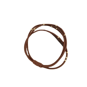 Brown multi-strand elastic hair tie with polished gold beads on a clean white background