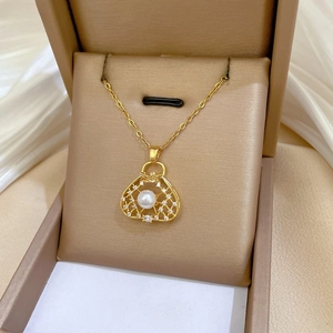Detailed close-up of hollow bag pendant with white pearl and sparkling crystals