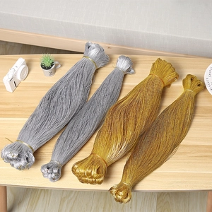 Rollos de cordón metálico dorado y plateado sobre fondo de madera rústica