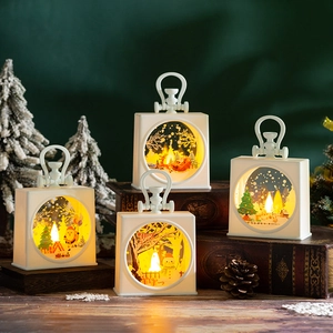 Detail of four white Christmas lanterns with warm LED lights on a festive tabletop