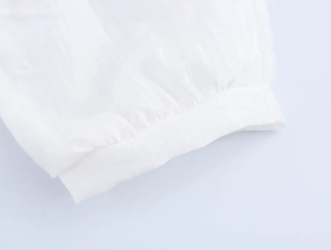 Gros plan détaillé des poignets de robe en dentelle blanche avec détails plissés fins