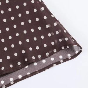Detailed view of the brown polka dot fabric with high-quality hem stitching and texture