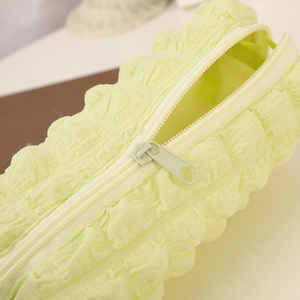 Detailed macro view of light green bubble texture and durable zipper on the soft fabric pencil case