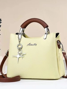 Fashionable light yellow bucket bag with brown handles and star charm shown in front view