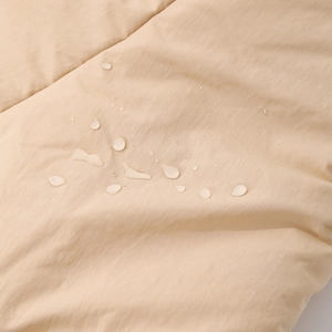 Waterproof fleece-lined bear hat showing water droplets on windproof fabric surface