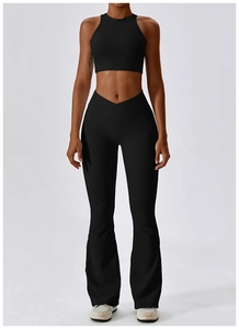 Detail of high-waisted flared yoga pants with V-shaped cross waistband design in black