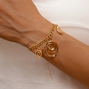Detail of gold chain bracelet with three spiral textured round charms on white background