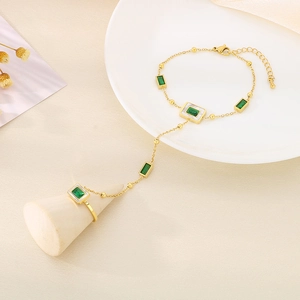 Detail of 18k gold plated slave bracelet with green rectangle zircon stones on chain